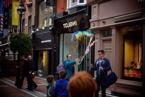 People on the street creating large bubbles